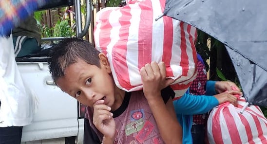 picture of small kid carrying a bag